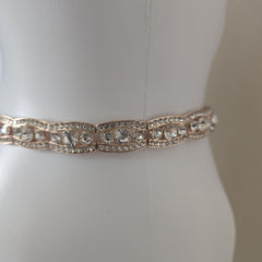 Rose gold belt on a mannequin against a white background