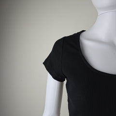 Black sleeveless top on a mannequin against a neutral background