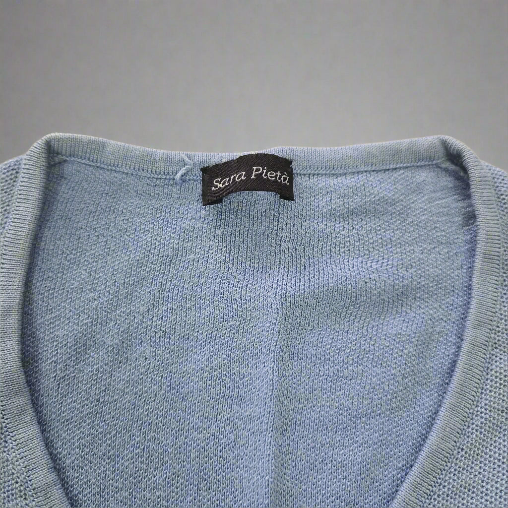 Close-up of a blue textured fabric with a label on a beige background