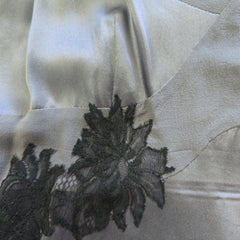Close-up of a black lace detail on a white fabric background