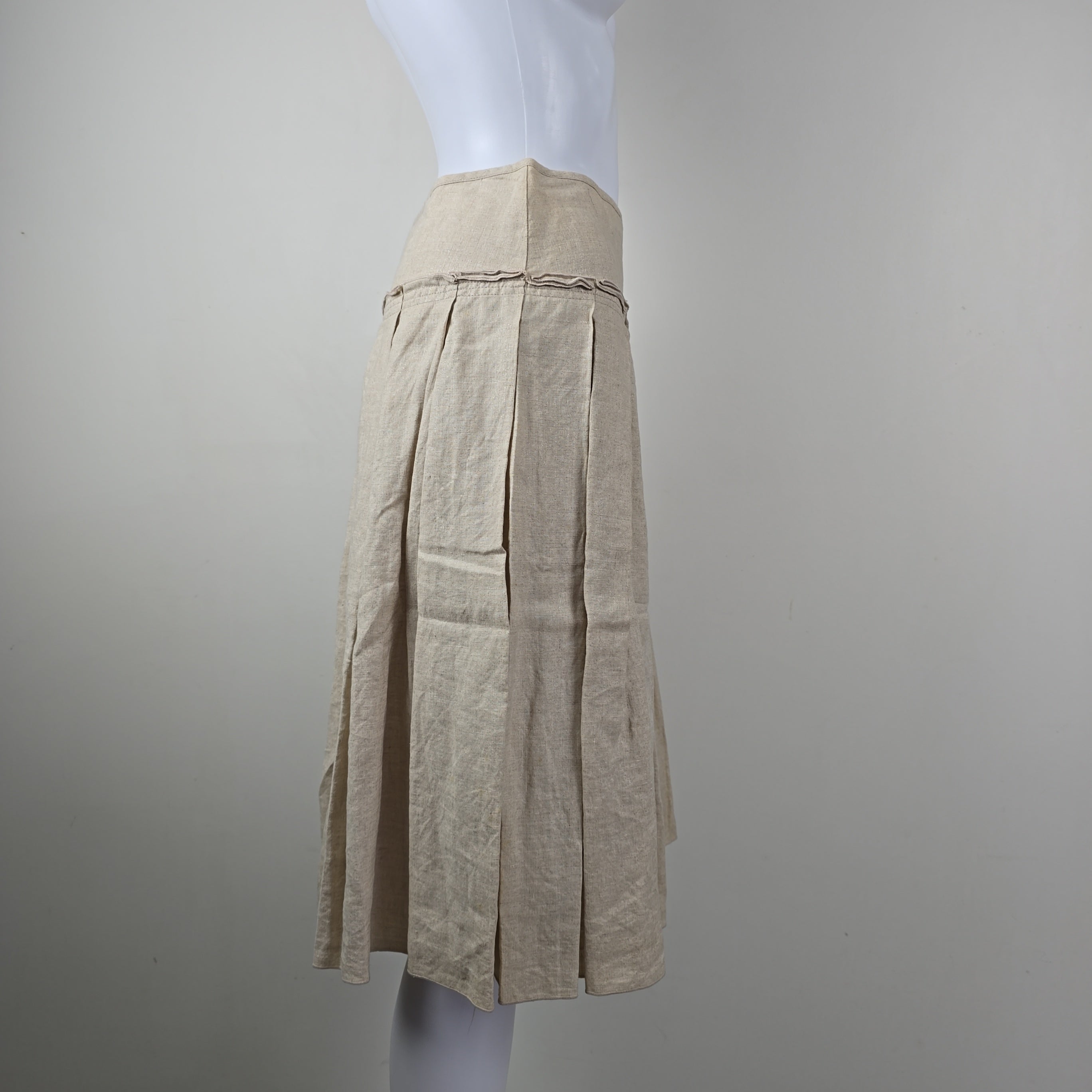 Stack of beige skirt on a white surface with a gray background