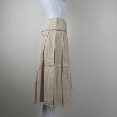 Stack of beige skirt on a white surface with a gray background