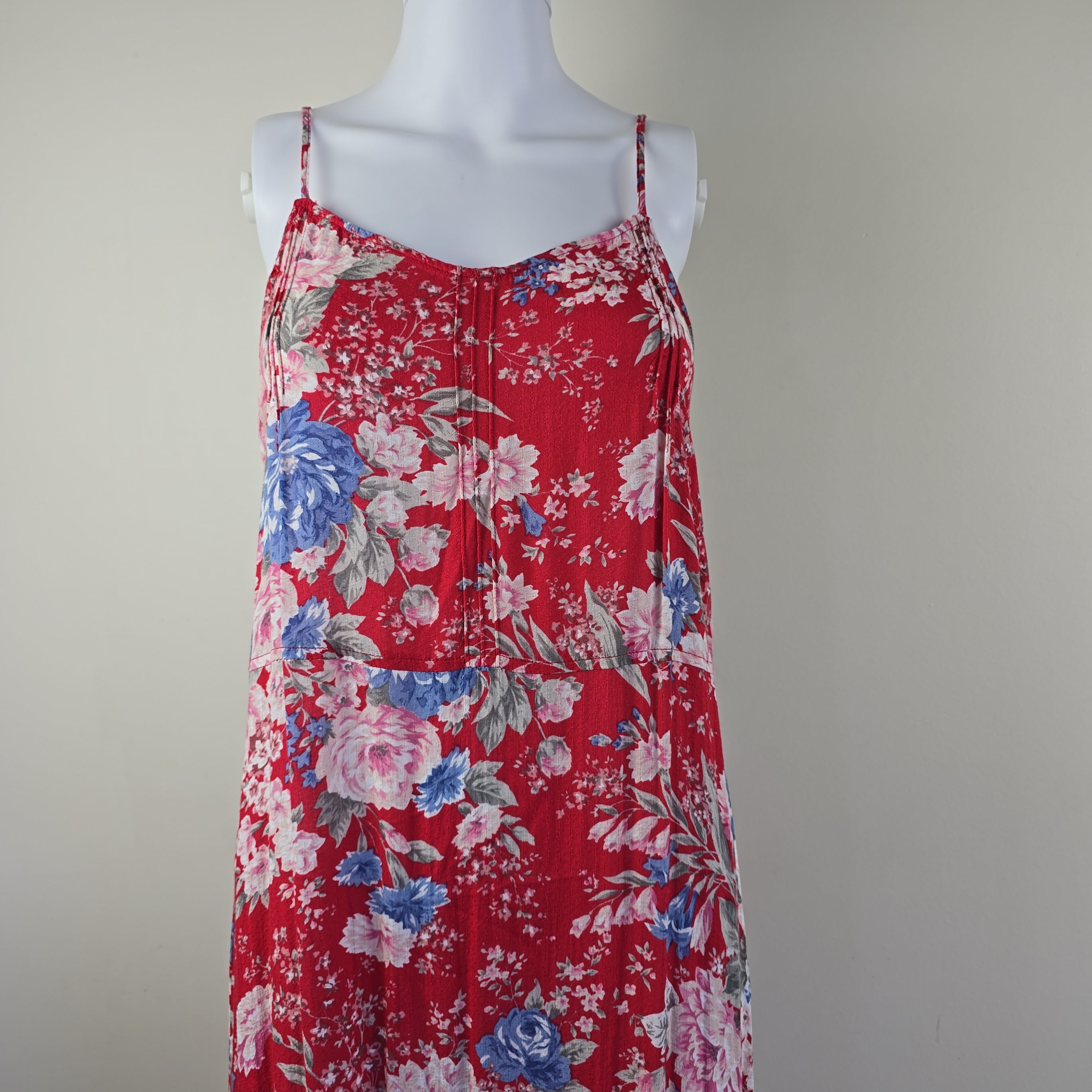 Red floral dress on a mannequin against a plain background