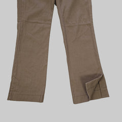 Brown pants laid flat on a white tiled floor