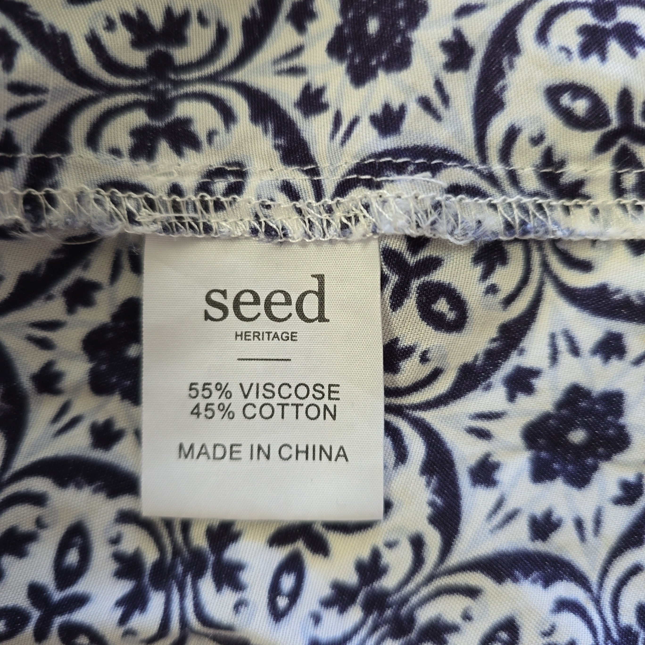 Fabric with a floral pattern and a 'seed' label indicating fabric composition and origin.