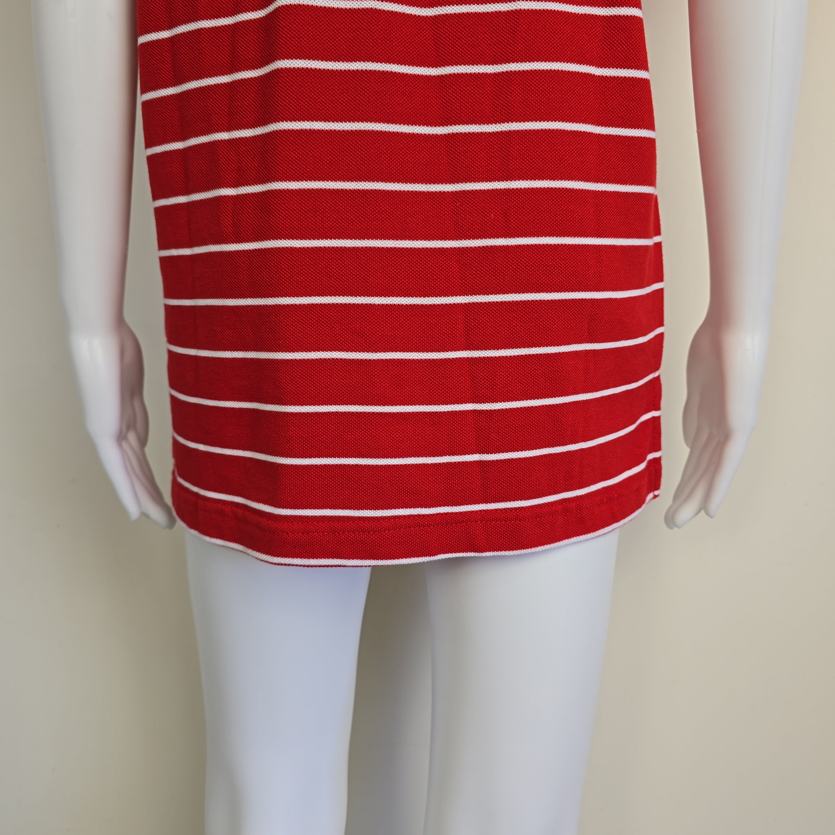 Mannequin wearing a red and white striped garment on a beige background