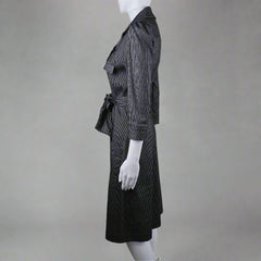 Mannequin wearing a black suit with white gloves on a neutral background