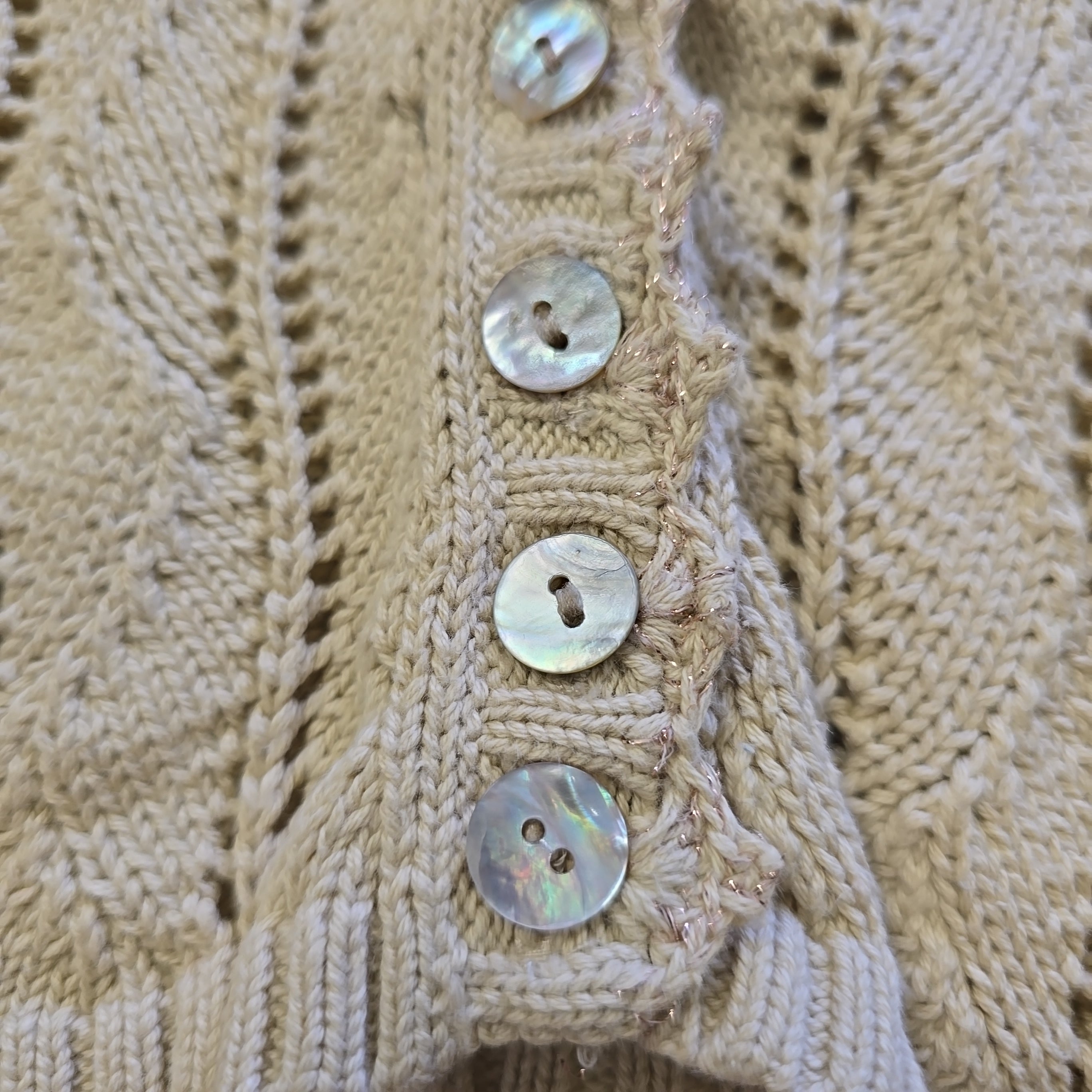 Close-up of a beige knitted fabric with button details