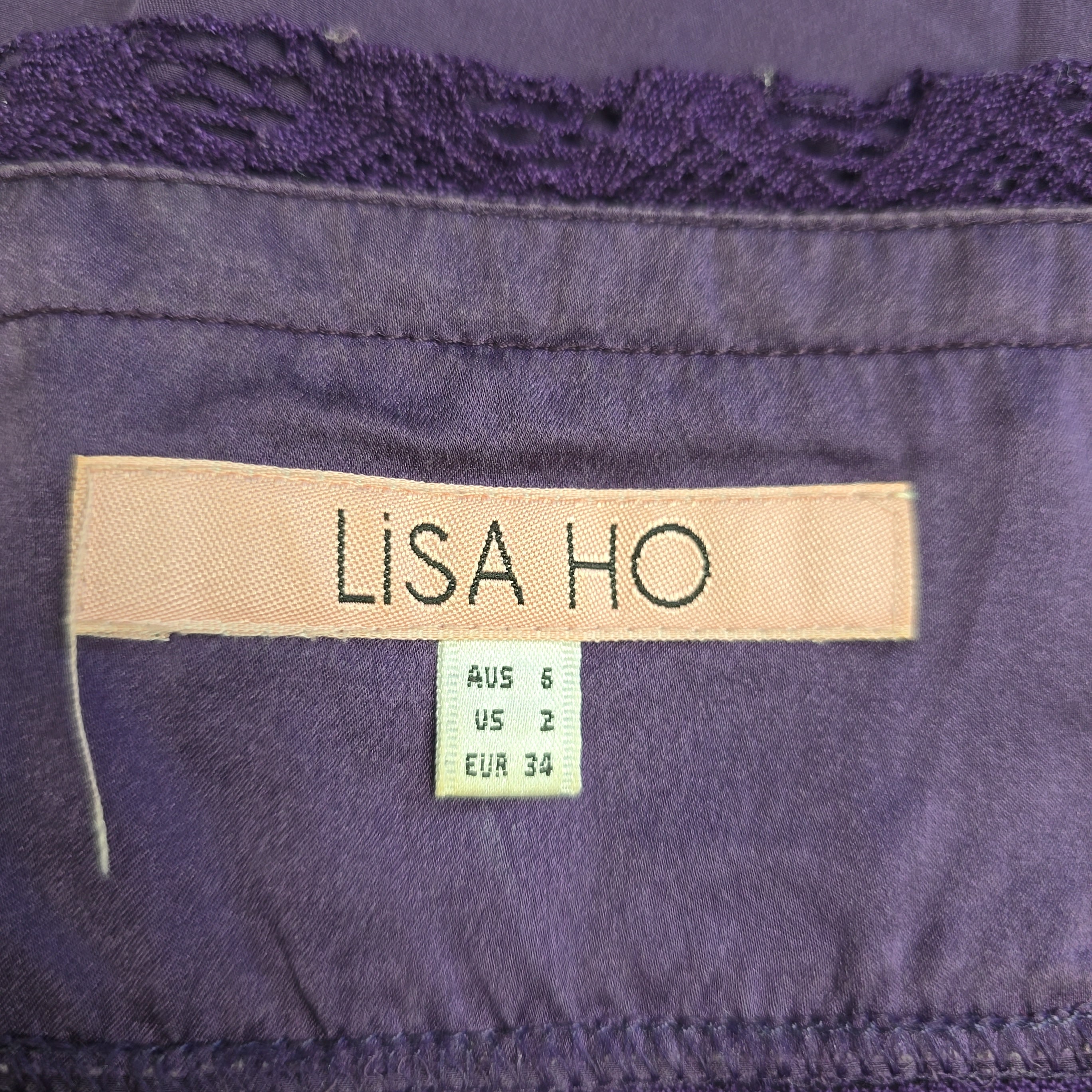 Close-up of a purple garment with a 'Lisa Ho' label.