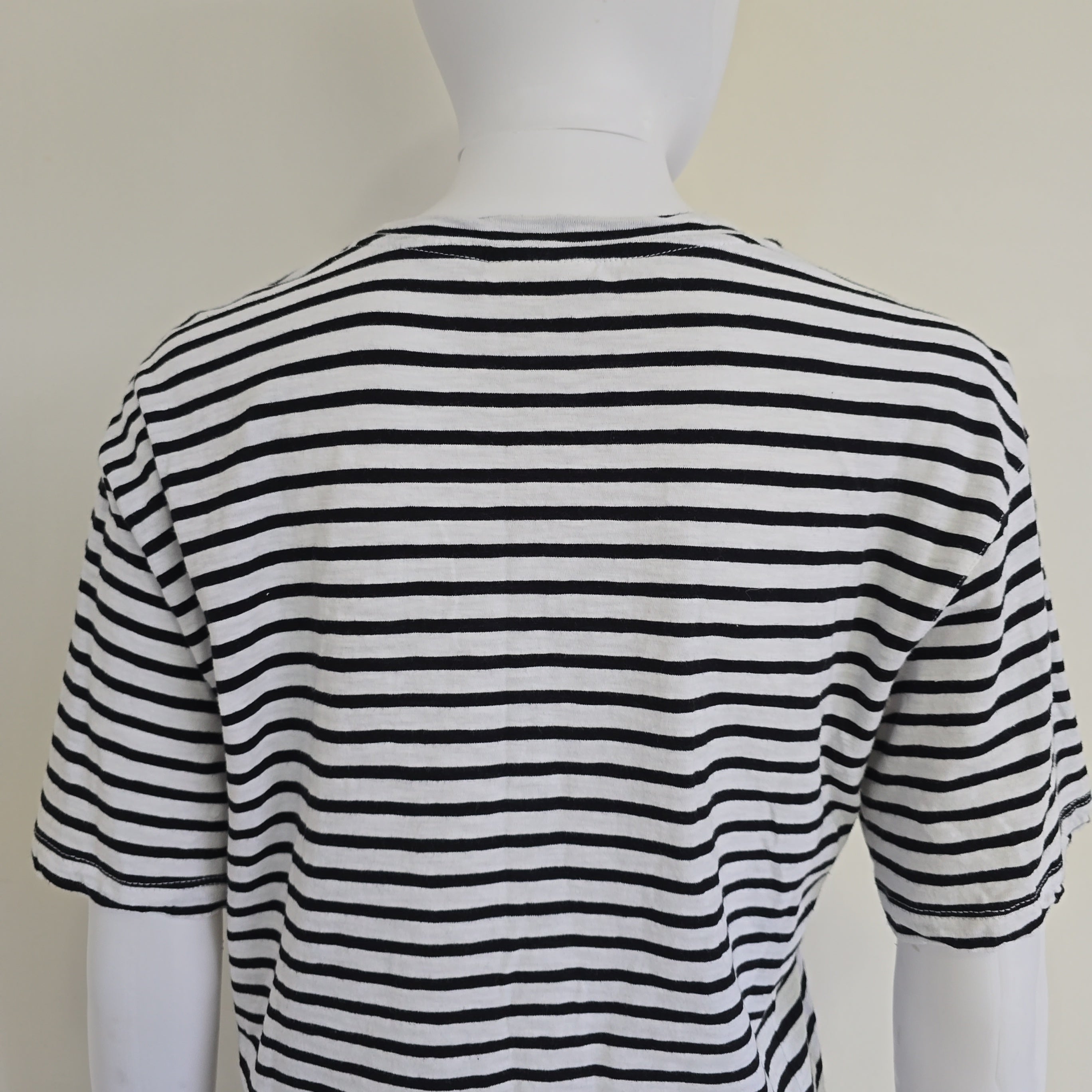 Black and white striped garment on a mannequin against a plain background