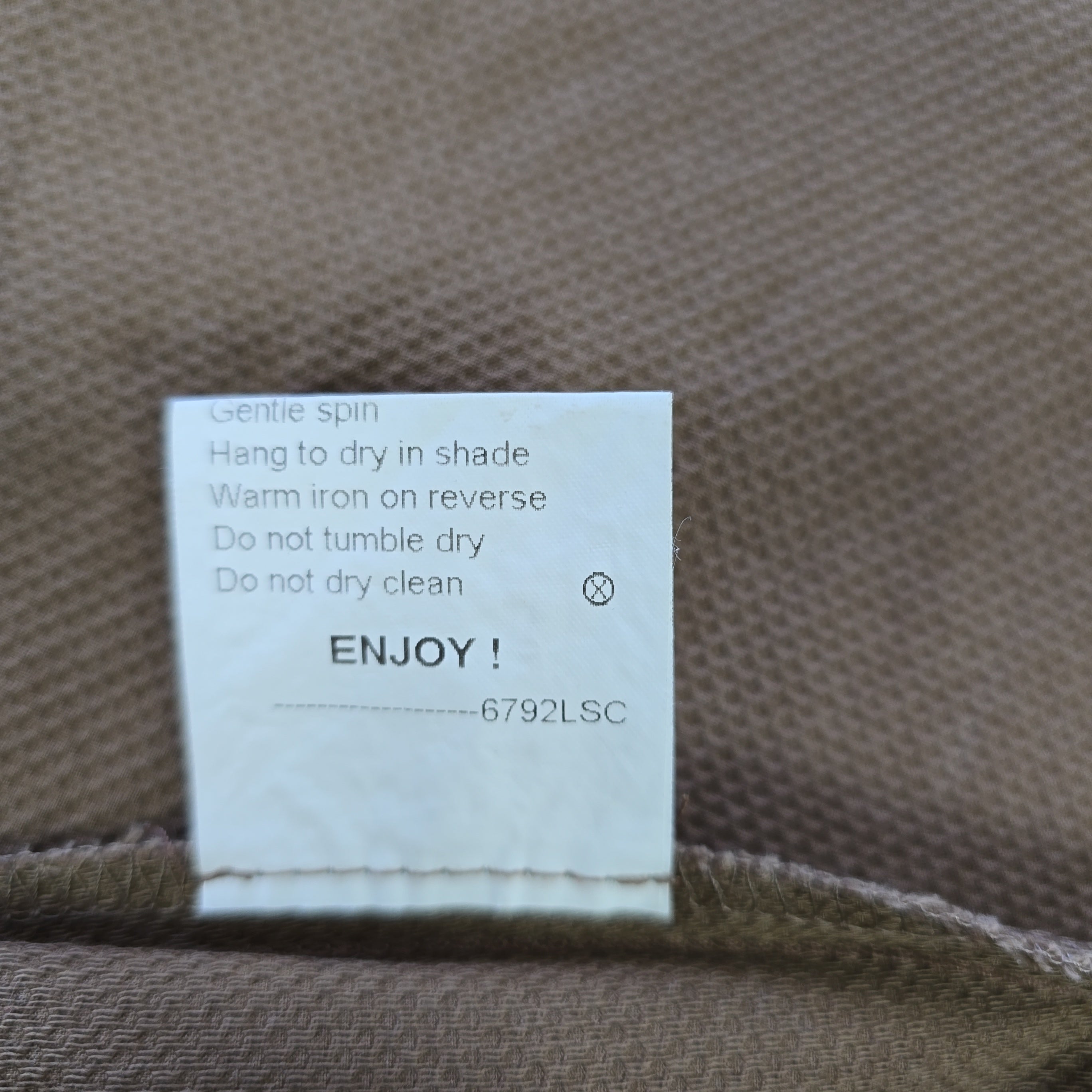 Clothing label with care instructions on a fabric background