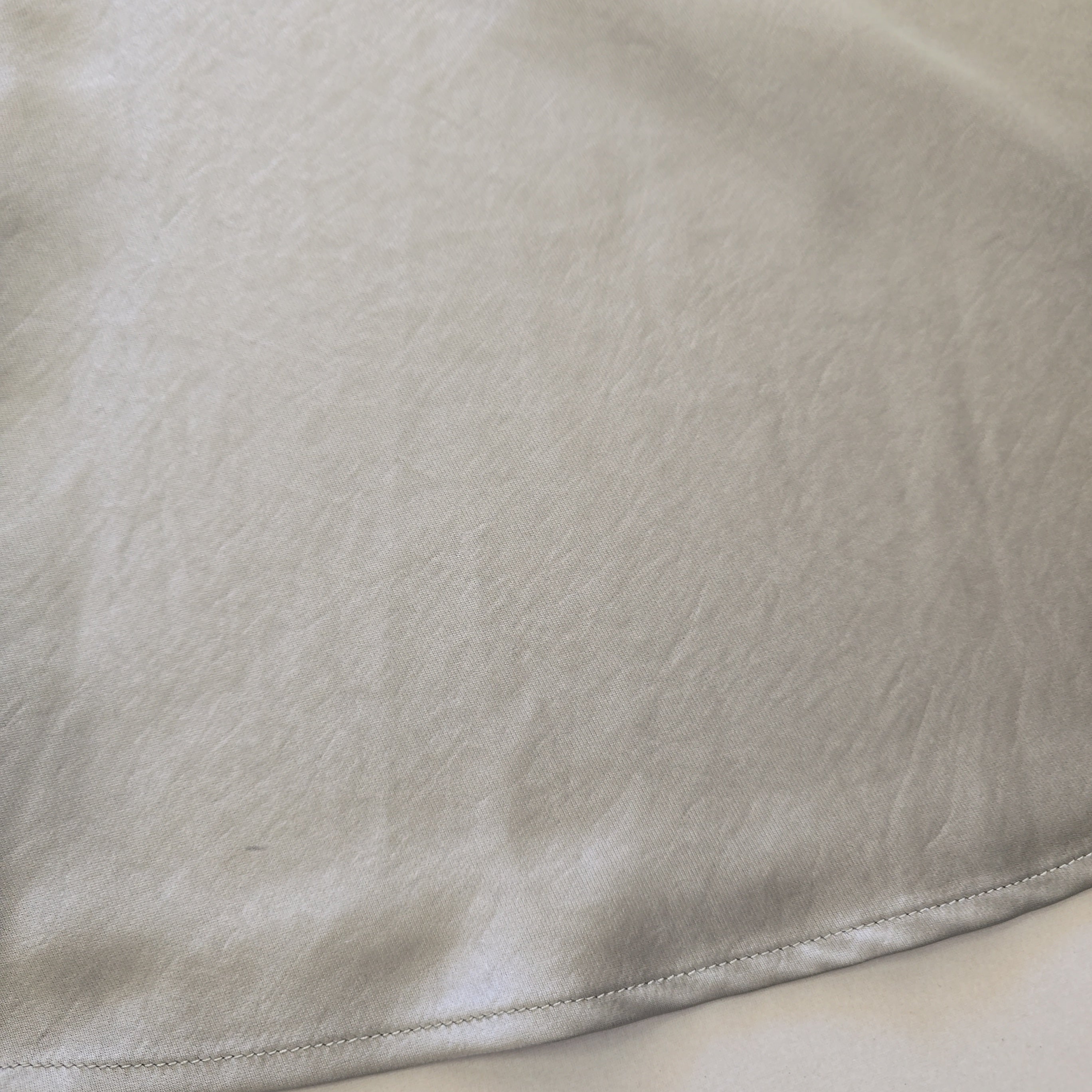 Close-up of beige fabric with a visible seam