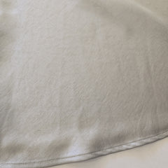 Close-up of beige fabric with a visible seam
