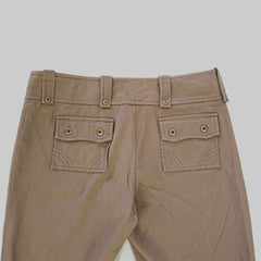 Close-up of brown pants with button details on a white background
