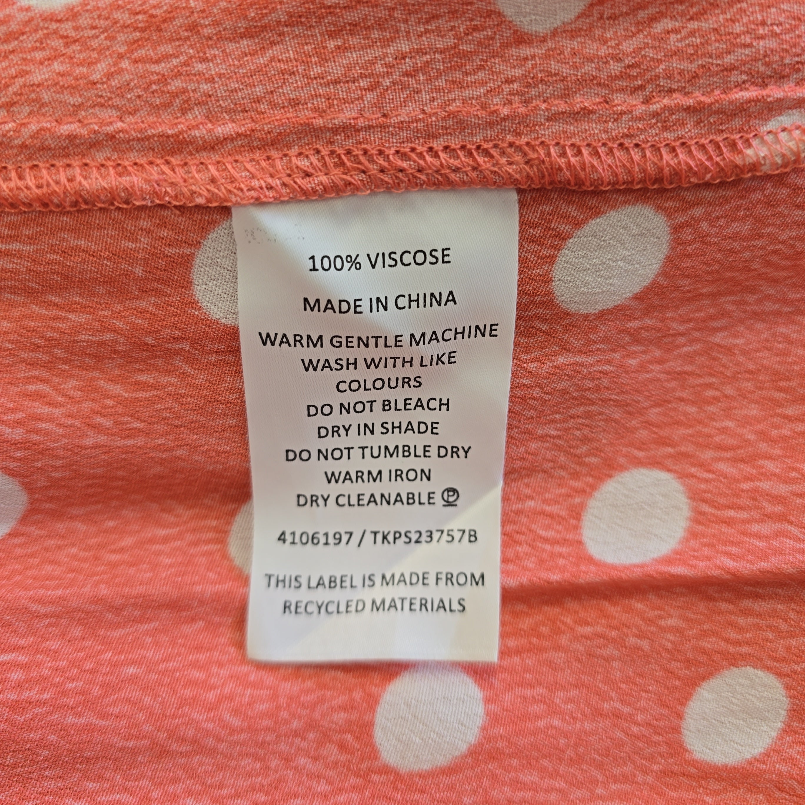 Fabric with a label on a pink and white polka dot background