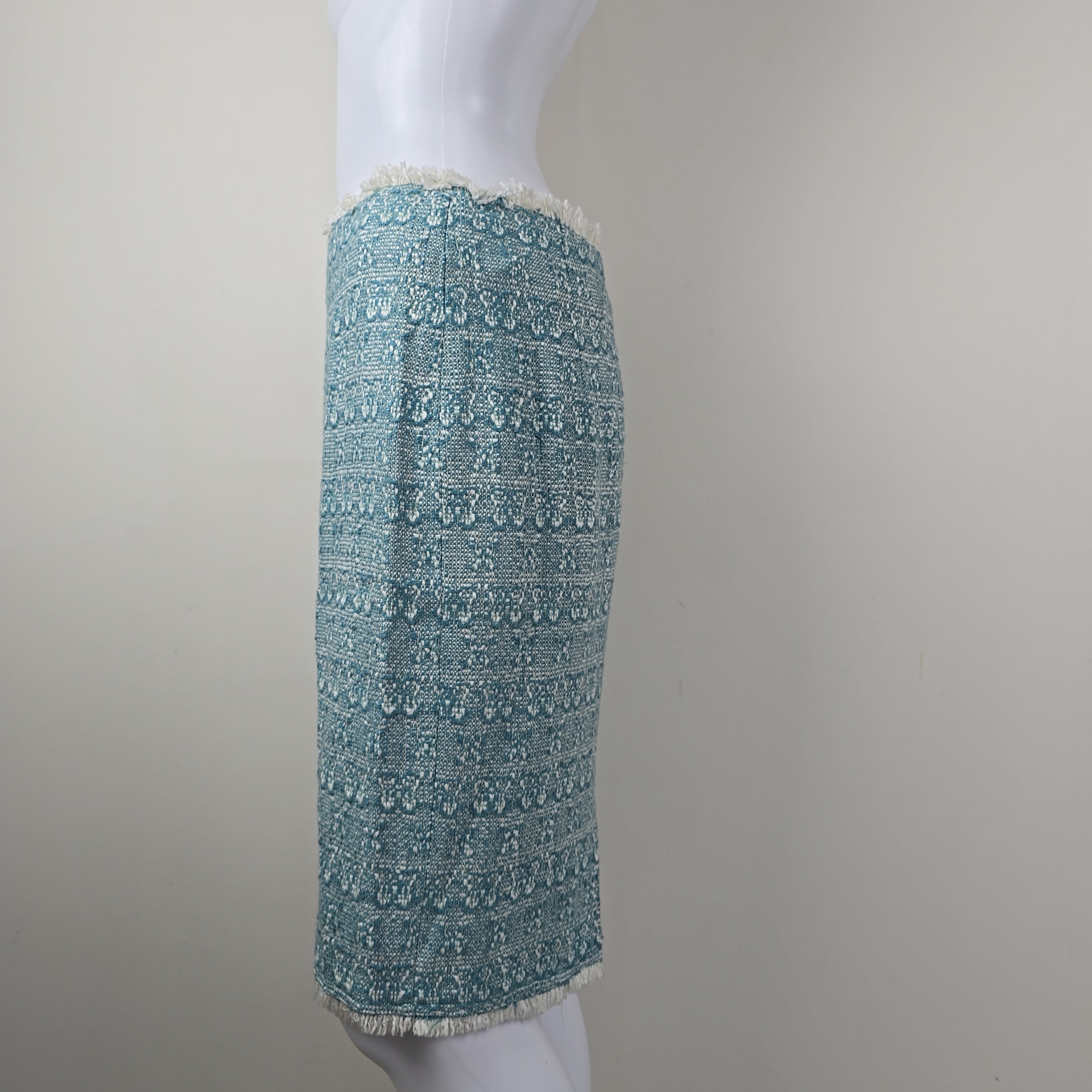 Textured blue skirt on a white mannequin arm against a gray background