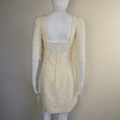 Beige lace garment on a mannequin against a plain background