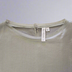Close-up of a light green Dress with a brand label on a neutral background