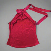 Red satin top with a bow on a tiled floor