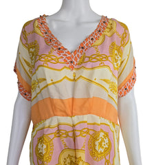 Mannequin wearing a dress with pink and gold pattern on a plain background