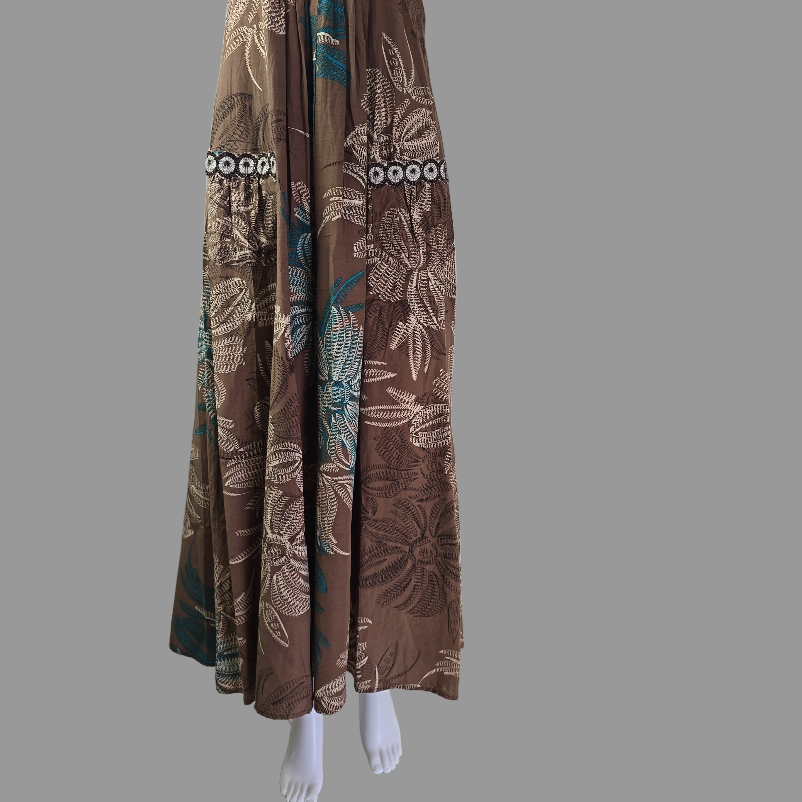 Stack of brown floral-patterned fabric against a white wall.