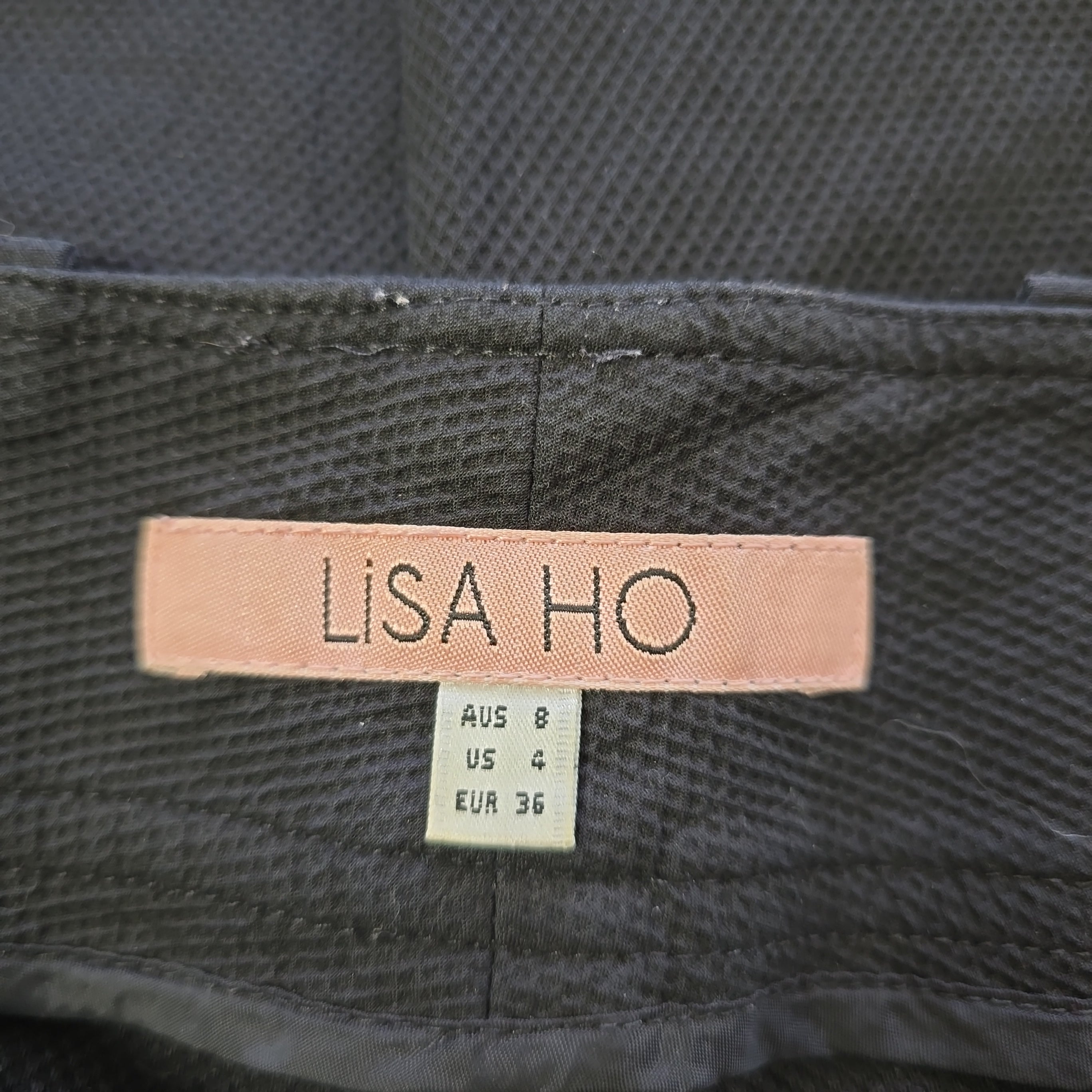 Close-up of a label on a garment with 'Lisa Ho' branding.