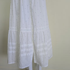White fabric skirt with a subtle pattern on a white background