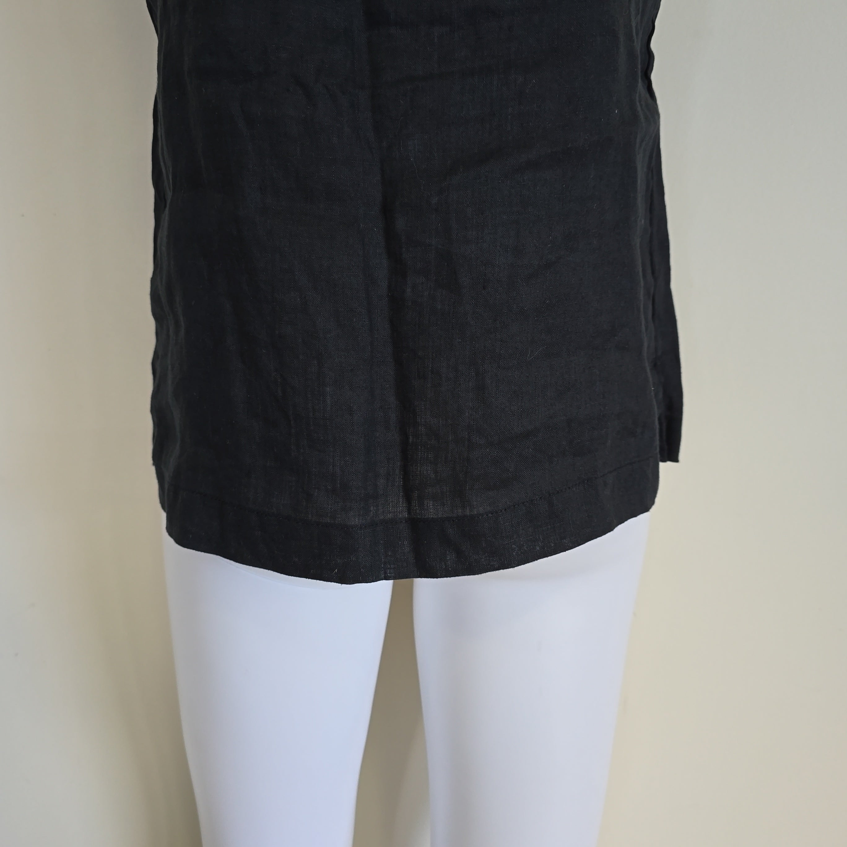 Black fabric draped over a mannequin on a beige background