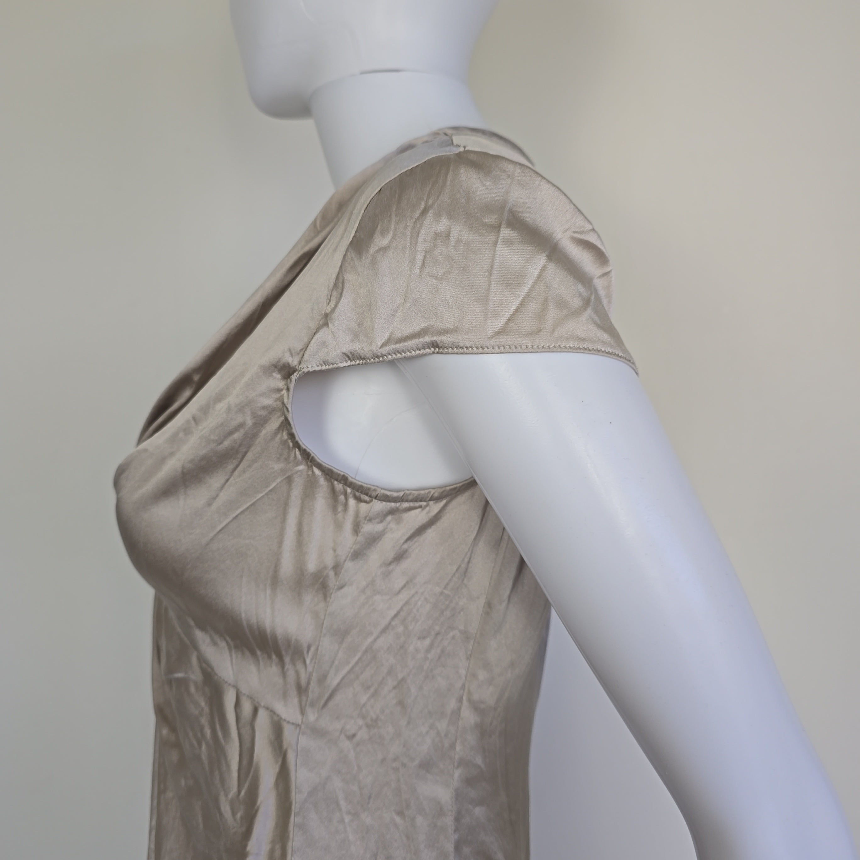 Mannequin wearing a beige top with a plain background