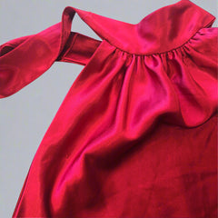 Close-up of a red satin fabric with a bow on a light background