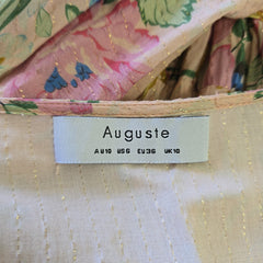 Fabric with a floral pattern and a visible brand label on a beige background