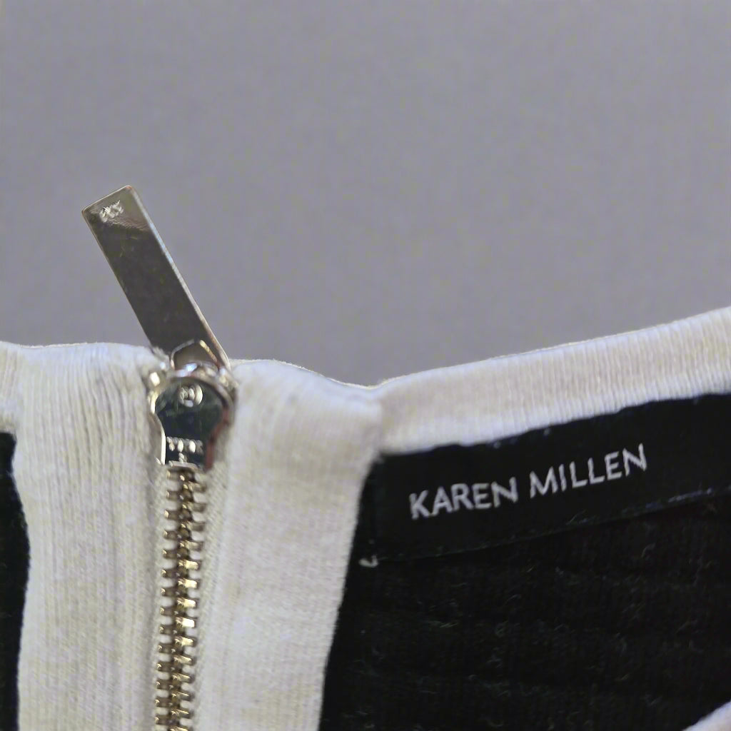 Close-up of a zipper on a garment with 'Karen Millen' branding.