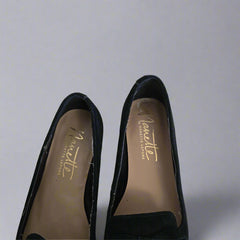 Black shoes with 'Nanette' branding on a tiled floor