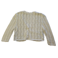 Folded beige knitted top on a tiled floor