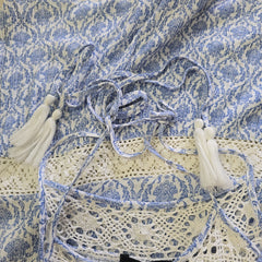 Close-up of a blue and white patterned fabric with lace details.