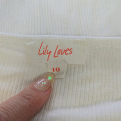 Close-up of a label on a garment with 'Lily Loves' text, held by a hand.