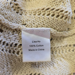 Close-up of a beige knitted fabric with a label on it.