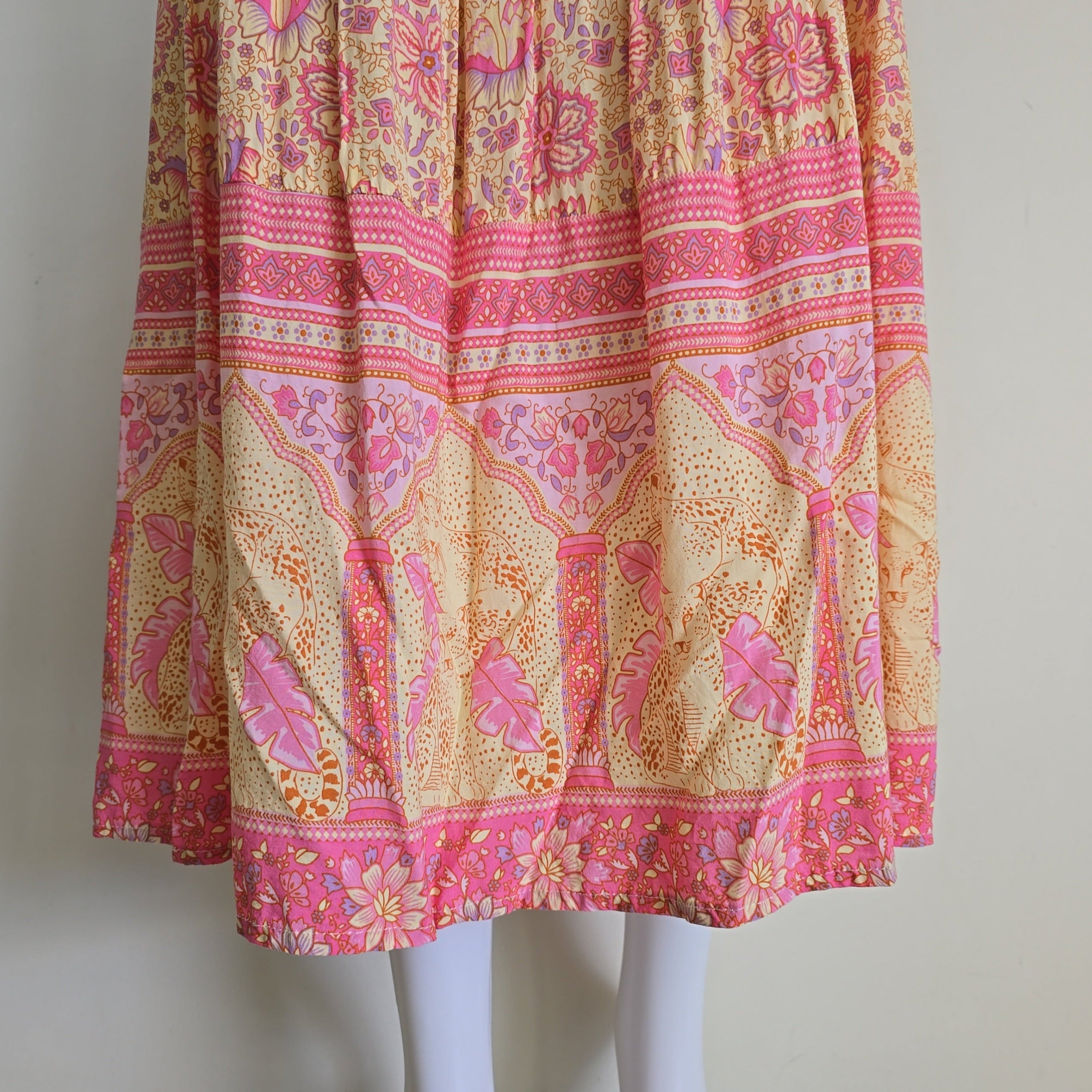 Folded pink and yellow patterned fabric on a white mannequin.