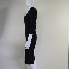 Black dress on a mannequin against a plain background