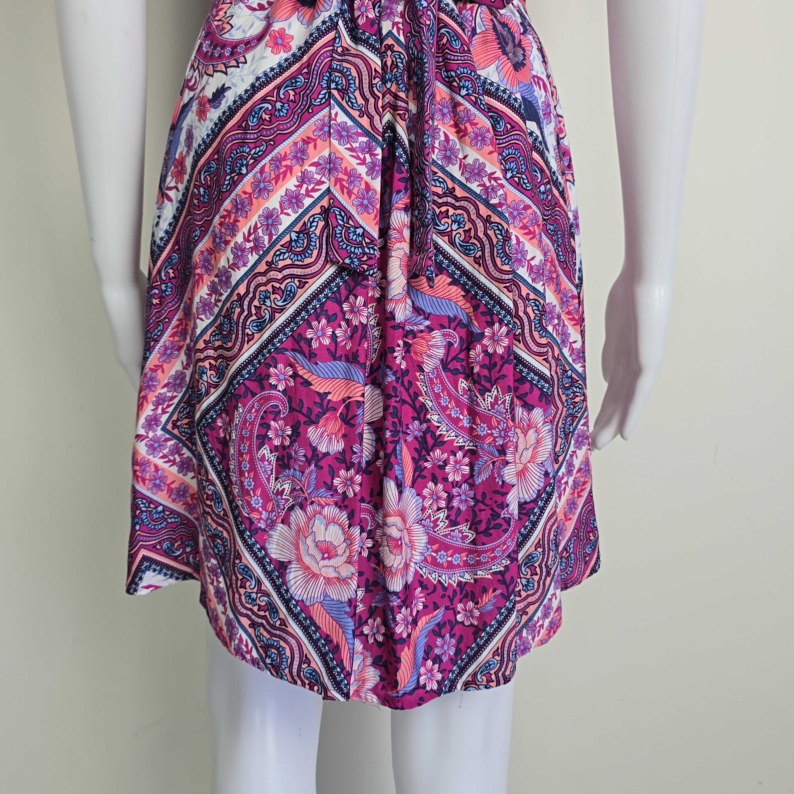 Pink and purple patterned fabric on a mannequin against a plain background