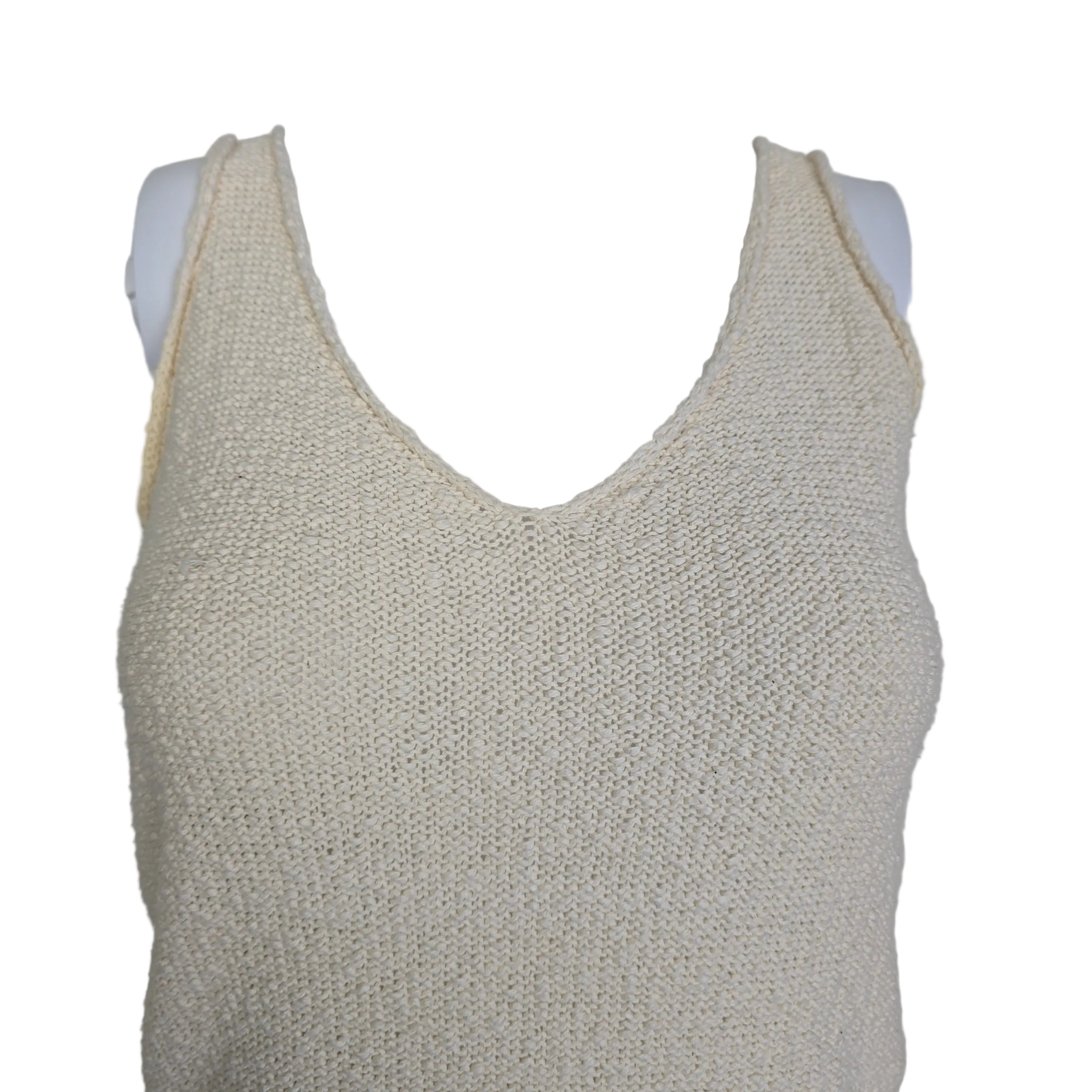 Mannequin wearing a beige textured top against a plain background