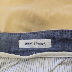 Close-up of a denim fabric with a 'Skinny' label on a beige background