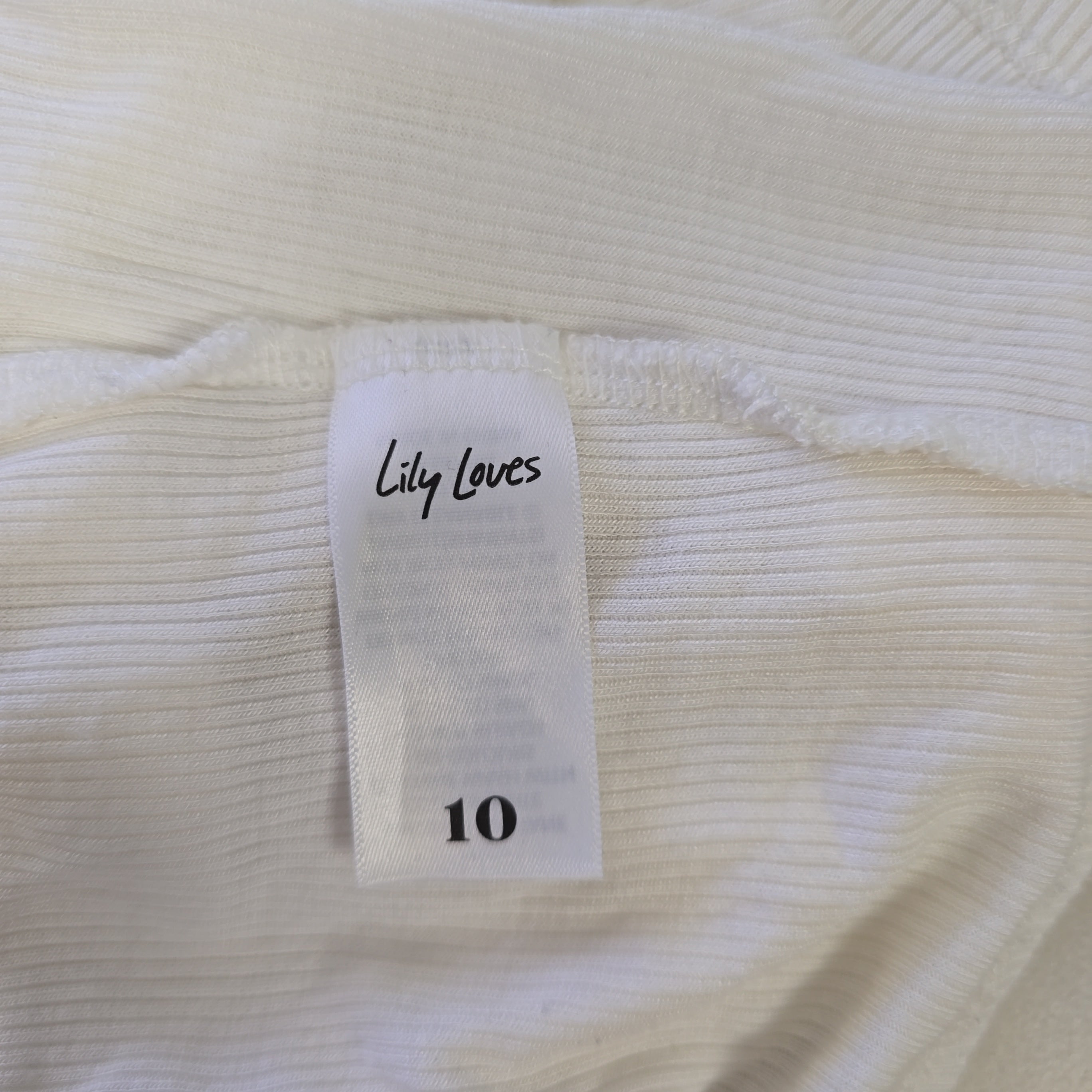 Close-up of a white garment with a label reading 'Lily Loves' and size '10'.