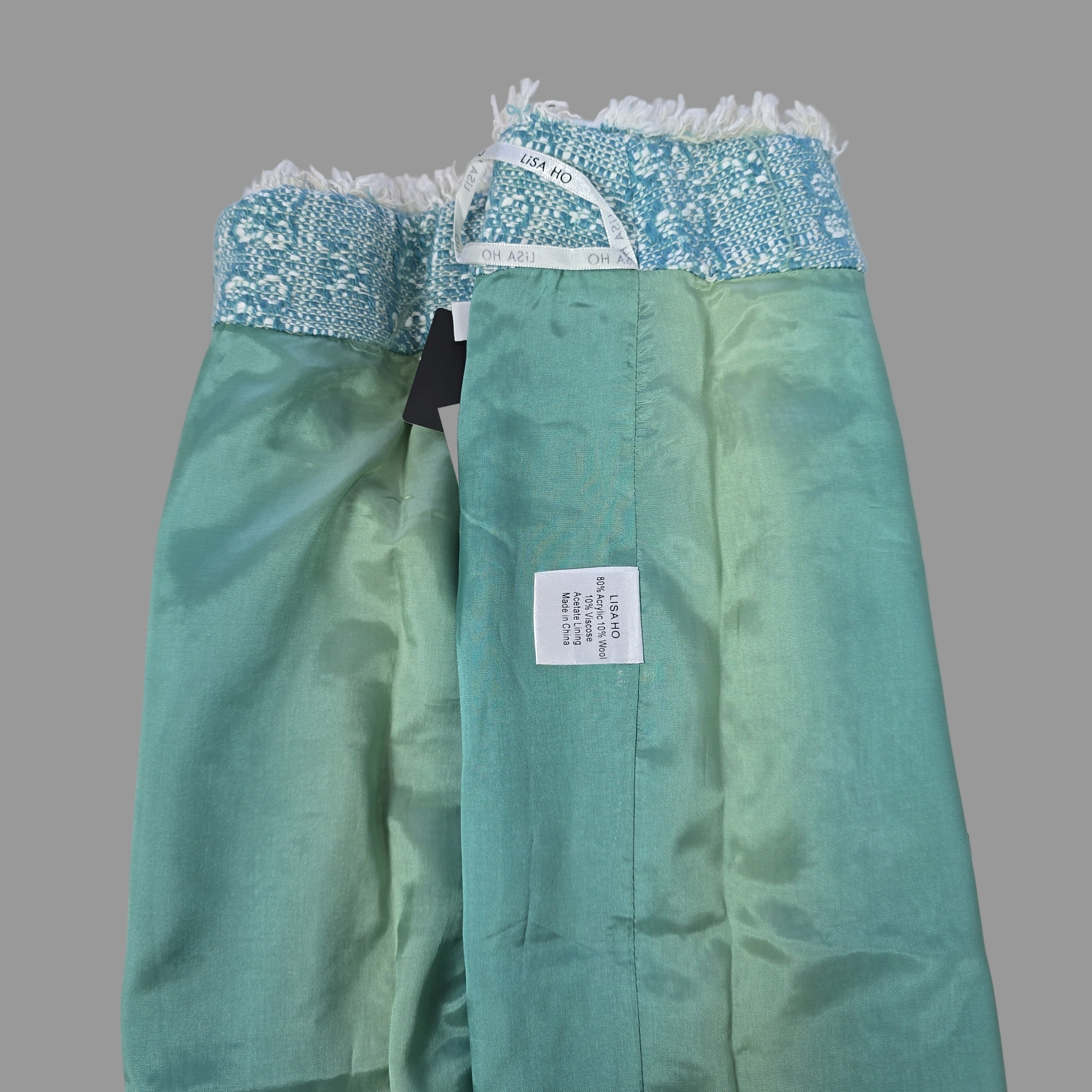 Green fabric with a label on a tiled floor