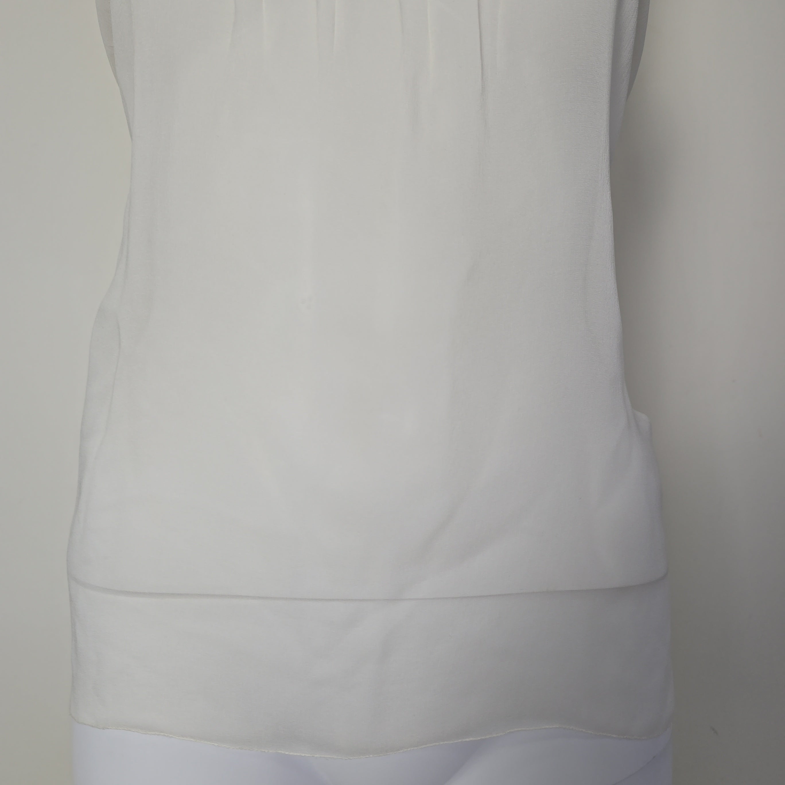 Close-up of a white top with a neutral background
