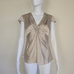 Beige top on a mannequin against a plain background