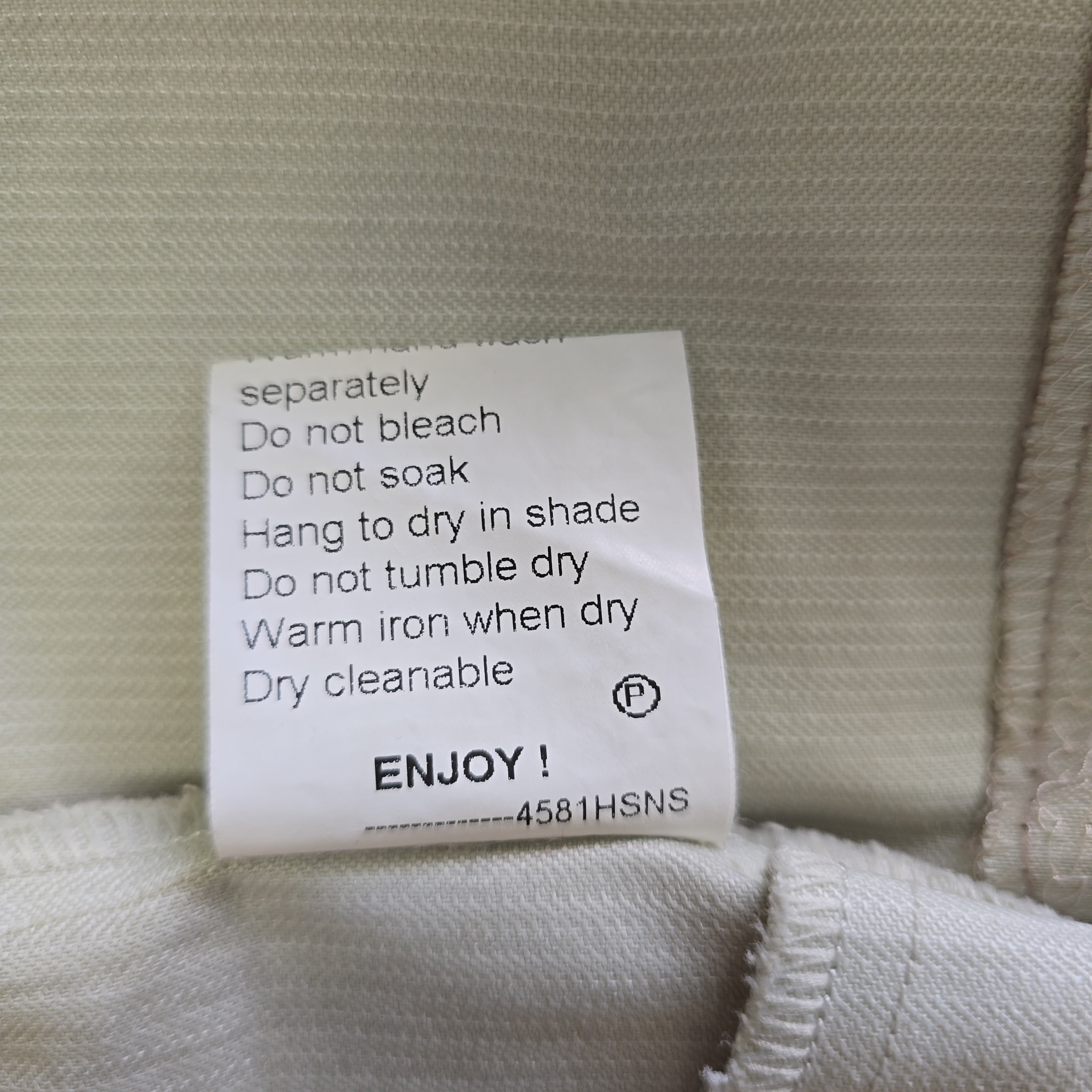 Clothing label with care instructions on a fabric background