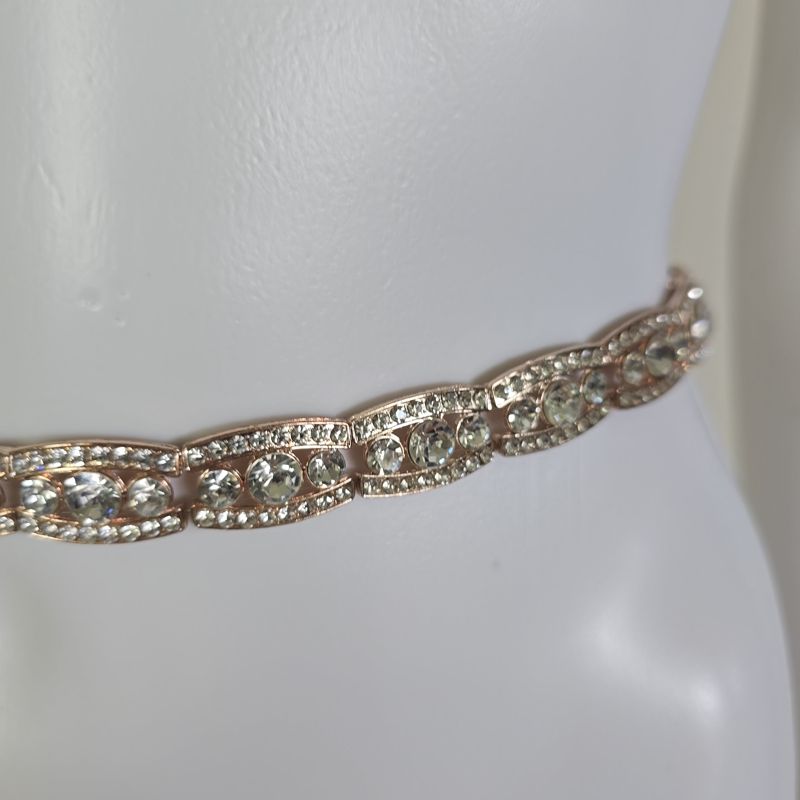 Rose gold belt on a mannequin against a white background