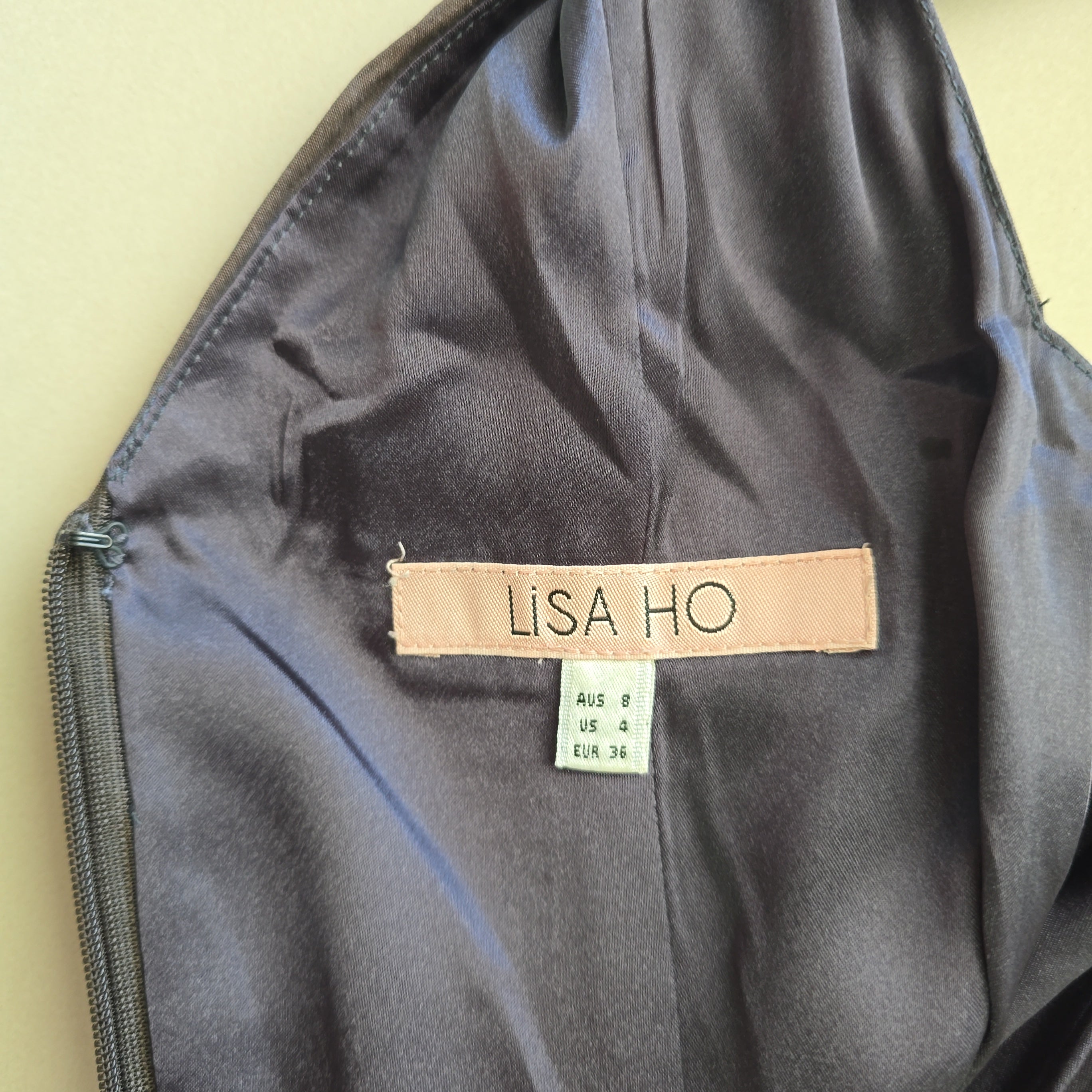 Black bag with a 'LISA HO' label on a beige background