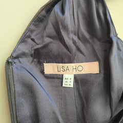 Black bag with a 'LISA HO' label on a beige background